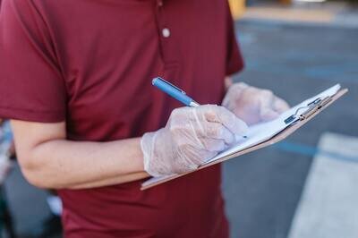 man writing on clipboard